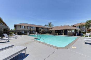 Chardonnay Ridge outdoor swimming pool surrounded by concrete sundeck. Lounge chairs spread out.
